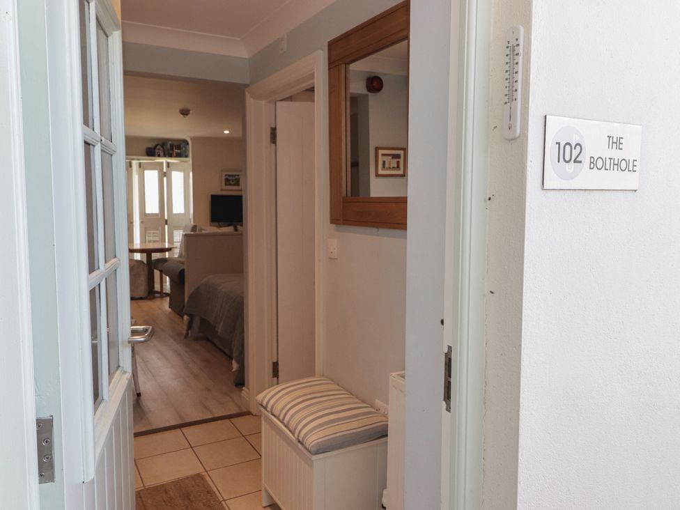 An entryway with a bench and mirror at The Bolthole in Newport