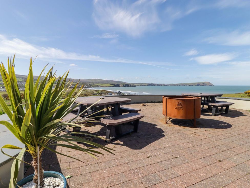 An outdoor seating area with tables and benches at The Bolthole in Newport