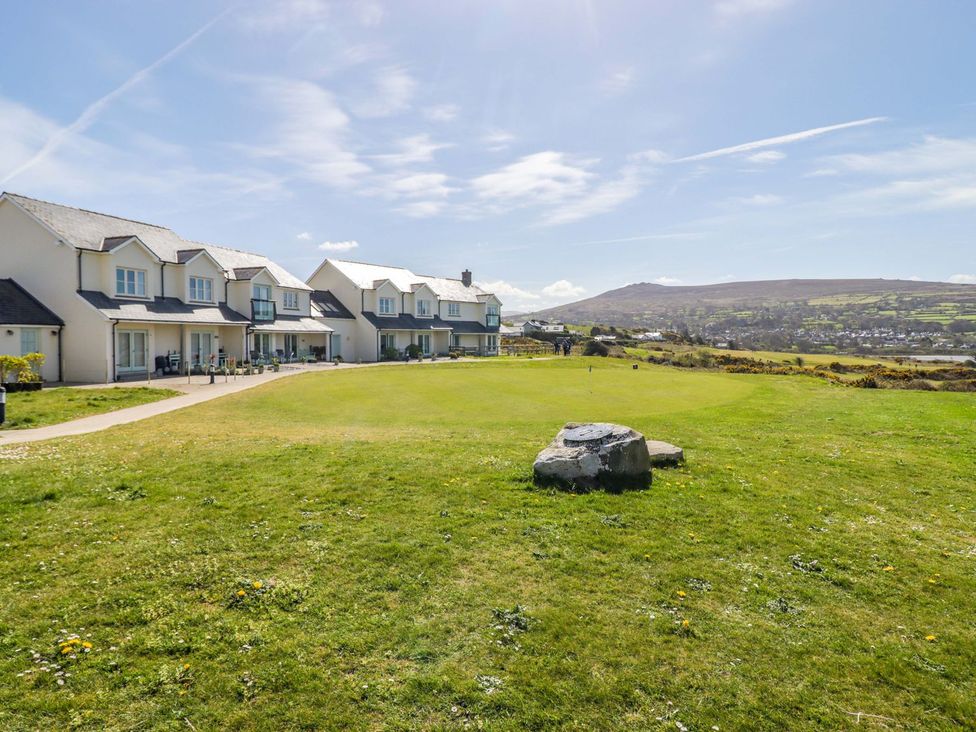 A view of houses with a grassy area and mountains in the background at The Bolthole in Newport