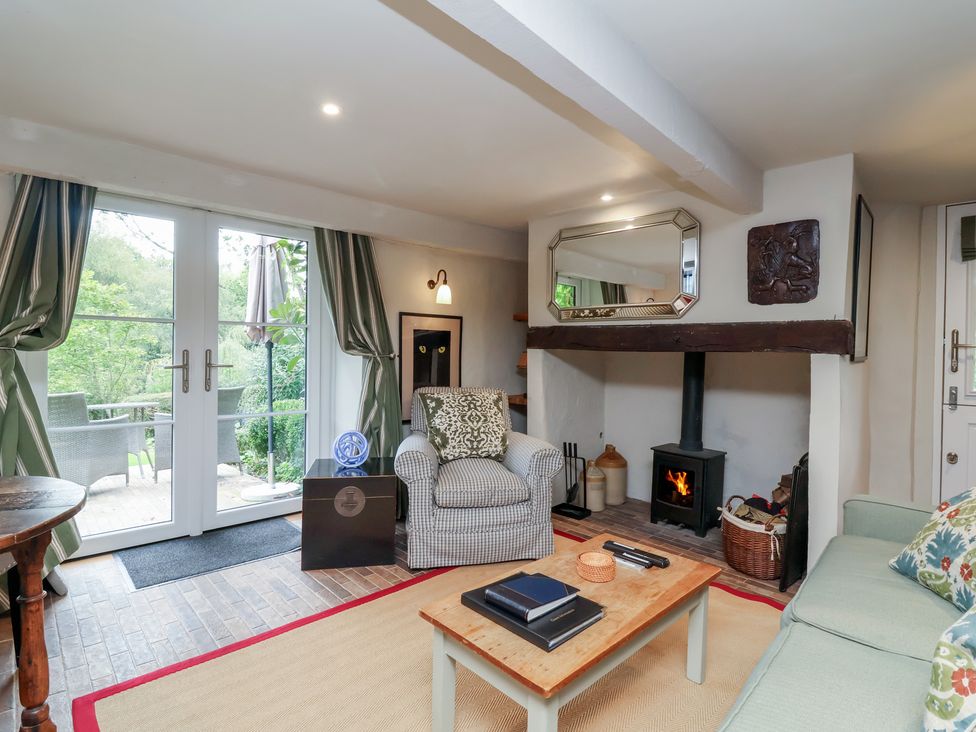 A living room with an armchair, sofa, and fireplace at The Bothy at Lewis Cottage in Spreyton