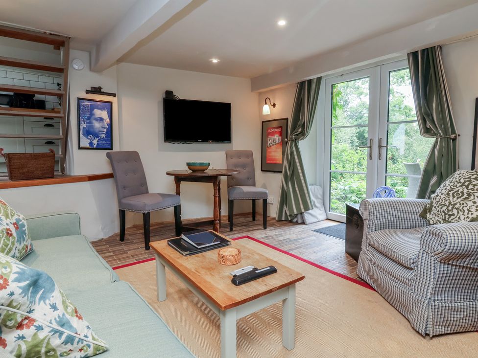 A living room with a sofa and chairs at The Bothy at Lewis Cottage in Spreyton