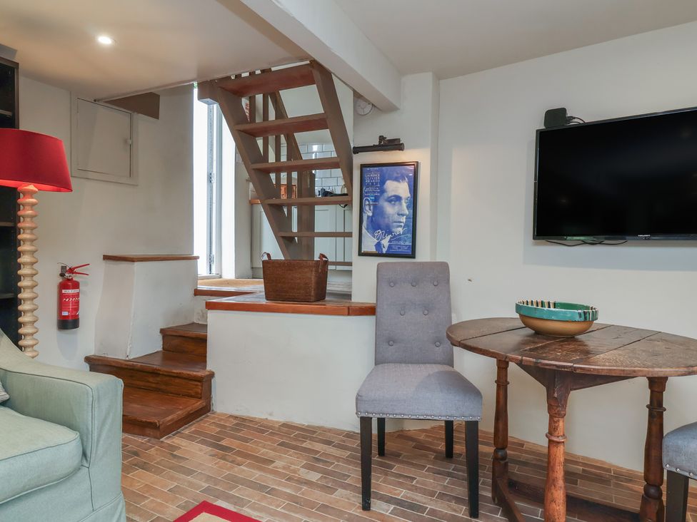 A living room with a staircase and television at The Bothy at Lewis Cottage Spreyton