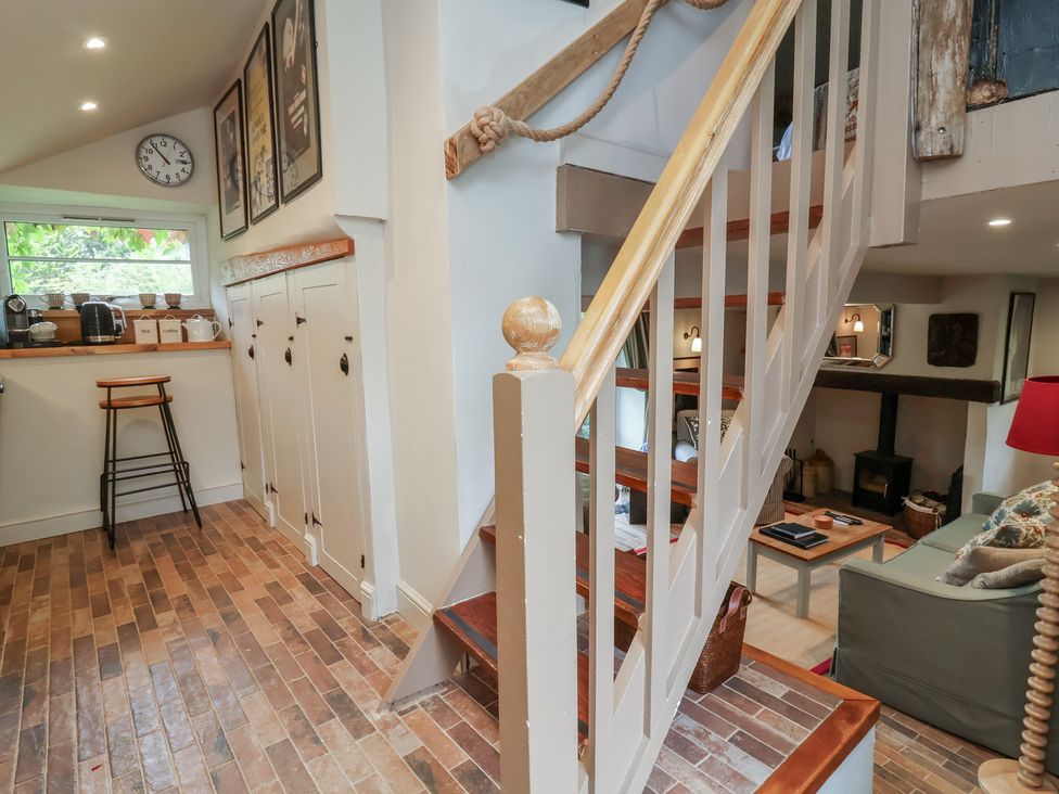 An entryway with a staircase and cabinets at The Bothy at Lewis Cottage in Spreyton