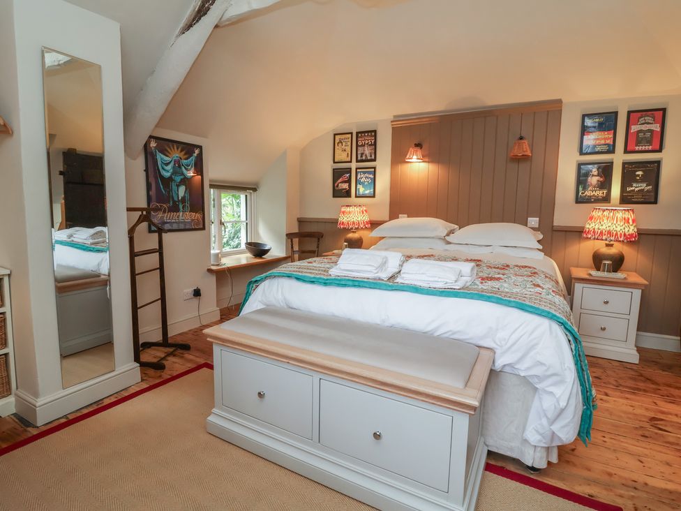 A bedroom with a bed and bedside tables at The Bothy at Lewis Cottage in Spreyton