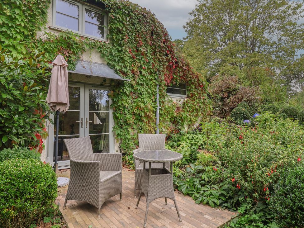 A garden with a table and chairs at The Bothy at Lewis Cottage in Spreyton