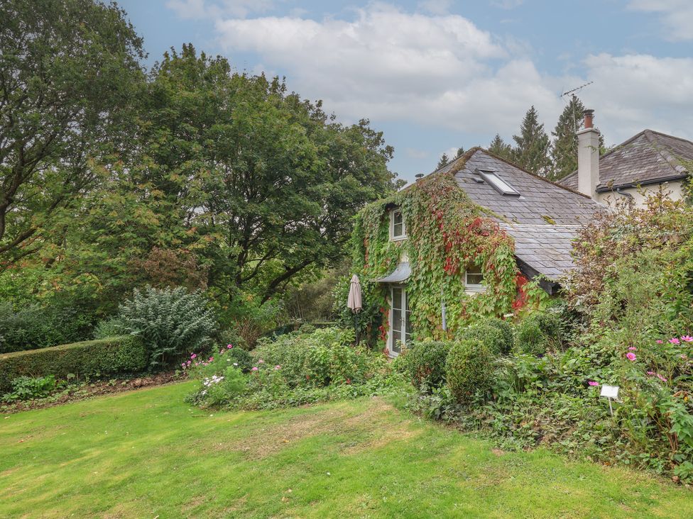 A house surrounded by garden and trees at The Bothy at Lewis Cottage in Spreyton