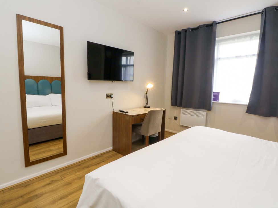 A bedroom with a mirror and a television at 2 bed no.1 Chorley