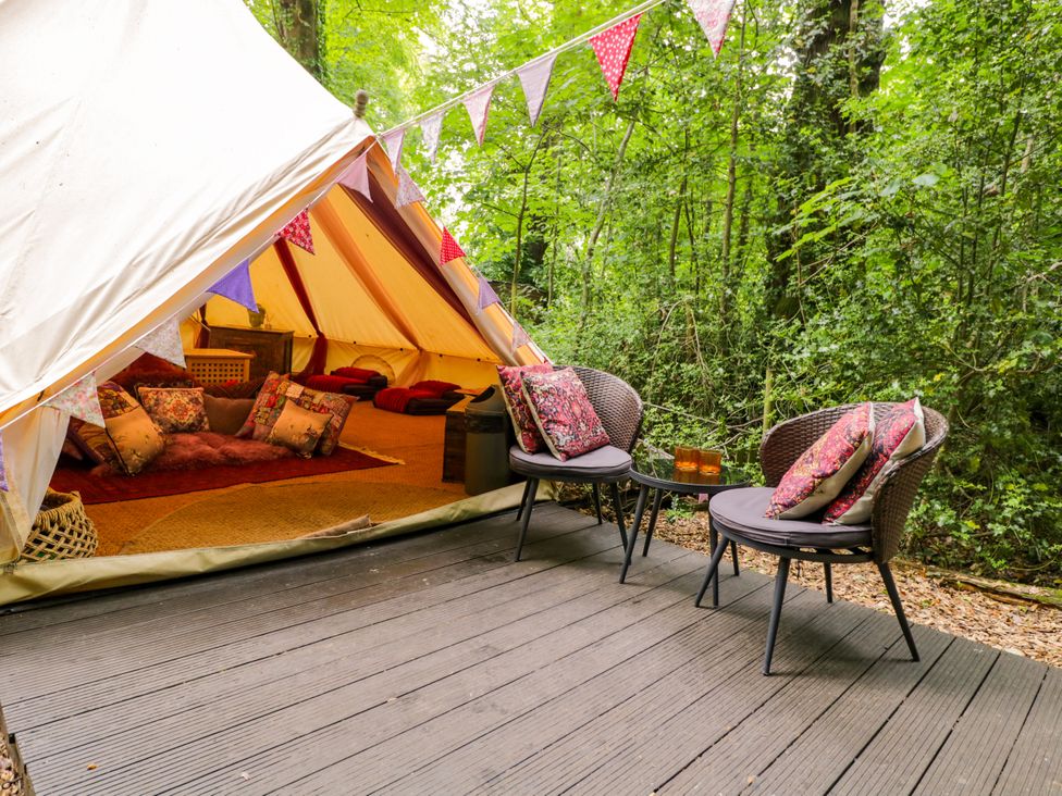 An outdoor area with a tent and seating at Bedouin Bell Tent in Woolton Hill