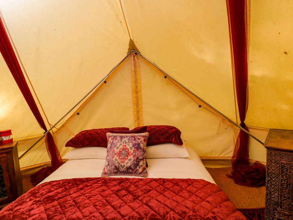 A bedroom with a bed and decorative items in Bedouin Bell Tent in Woolton Hill