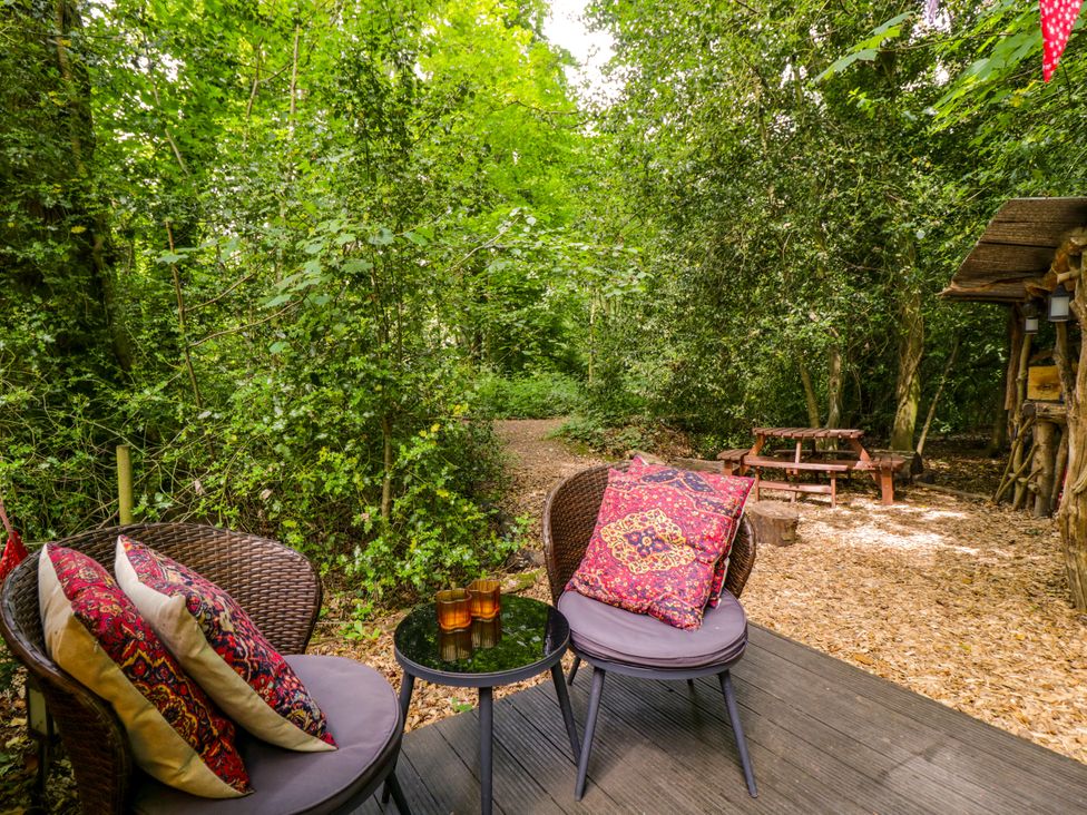 An outdoor seating area with chairs and a table at Bedouin Bell Tent in Woolton Hill