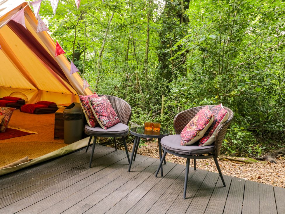 A seating area with two chairs and a table outside a tent at Bedouin Bell Tent in Woolton Hill