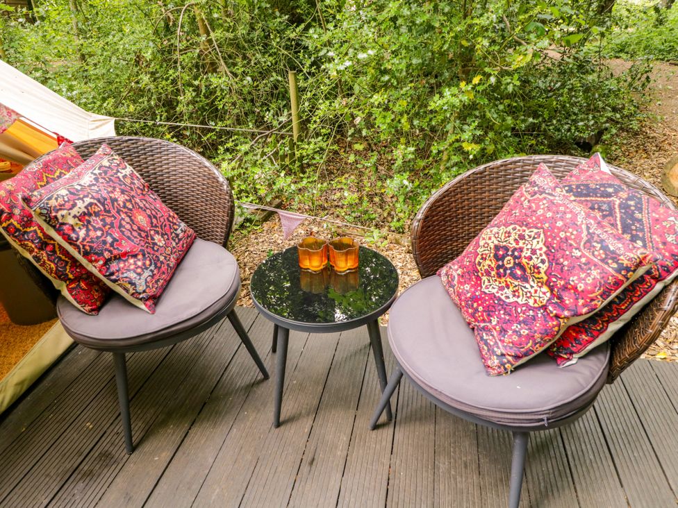 An outdoor seating area with two chairs and a table at Bedouin Bell Tent in Woolton Hill