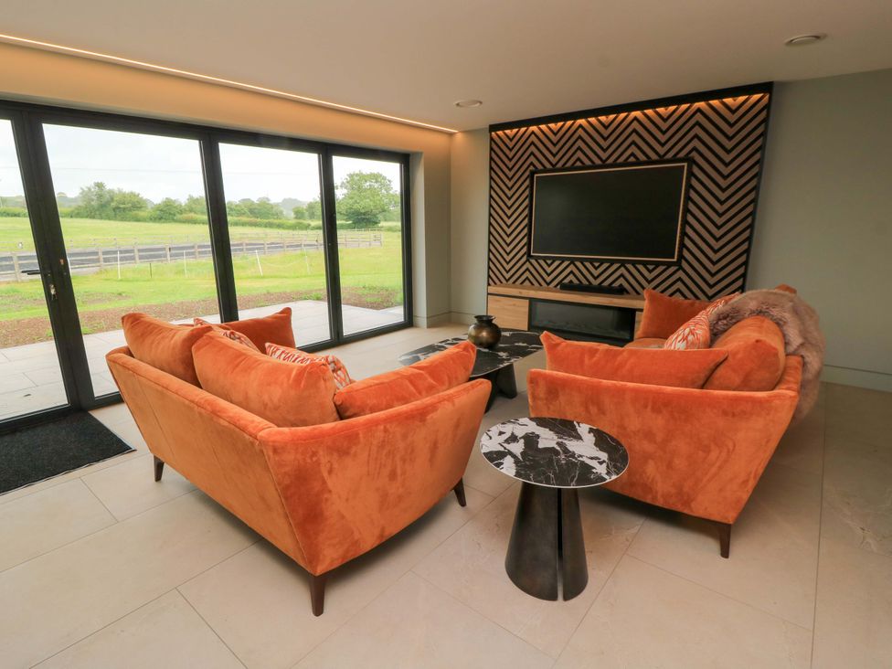 A living room with two sofas and a television at The Cozy Sow in Yeovil
