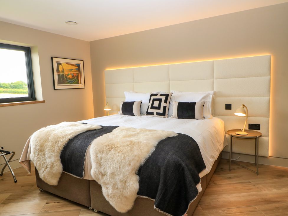 A bedroom with a large bed and window at The Cozie Sow in Galhampton