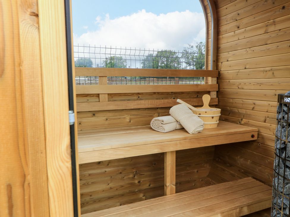 A sauna with wooden benches and a bucket at The Cozie Sow in Galhampton