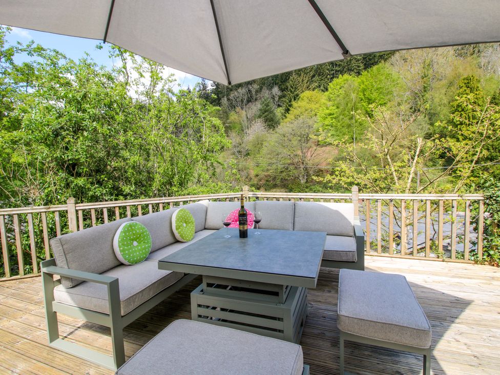 An outdoor seating area with a table and sofa at Little Pentwyn in Clyro