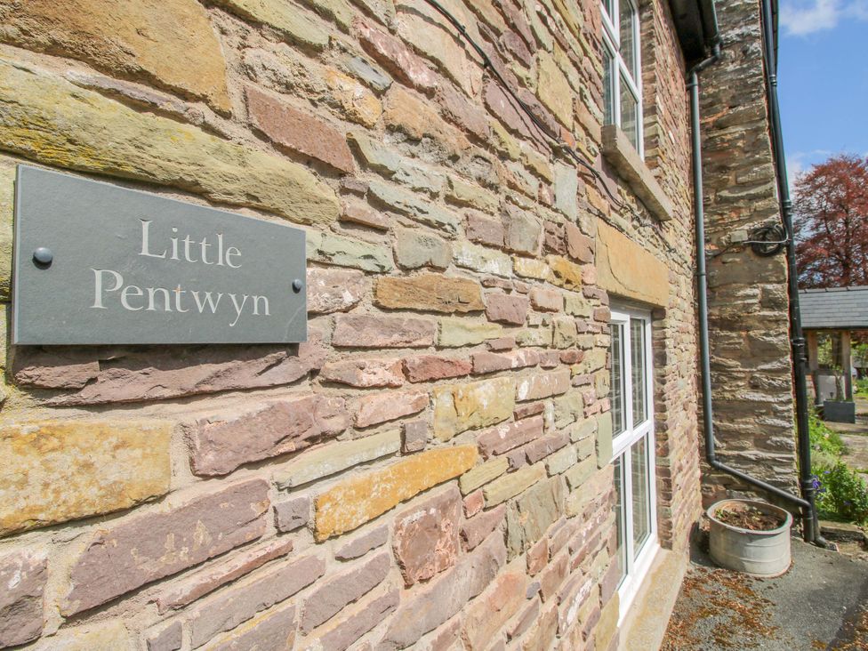 A stone wall with a sign displaying Little Pentwyn outside the property Little Pentwyn in Clyro