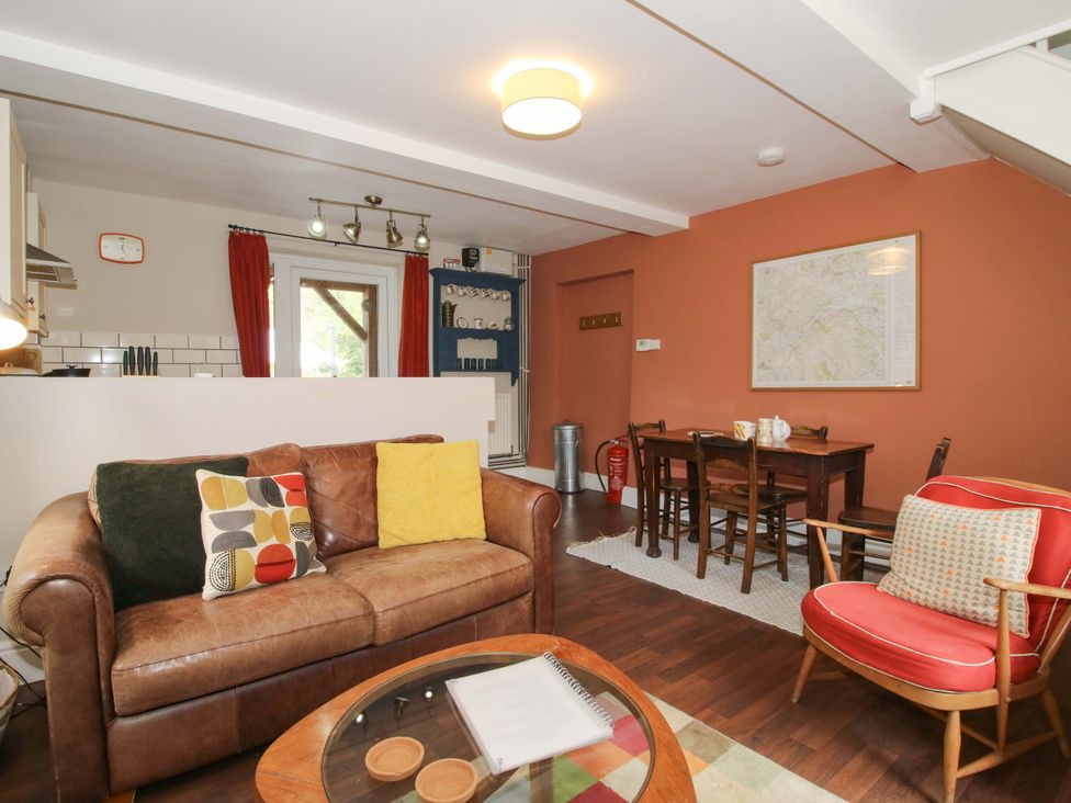 A living room with a sofa and dining table at Little Pentwyn in Clyro