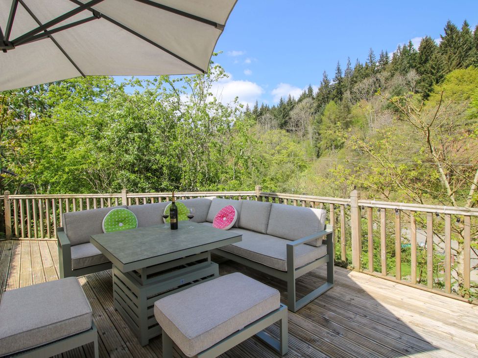 A deck with outdoor seating and a table at Little Pentwyn in Clyro