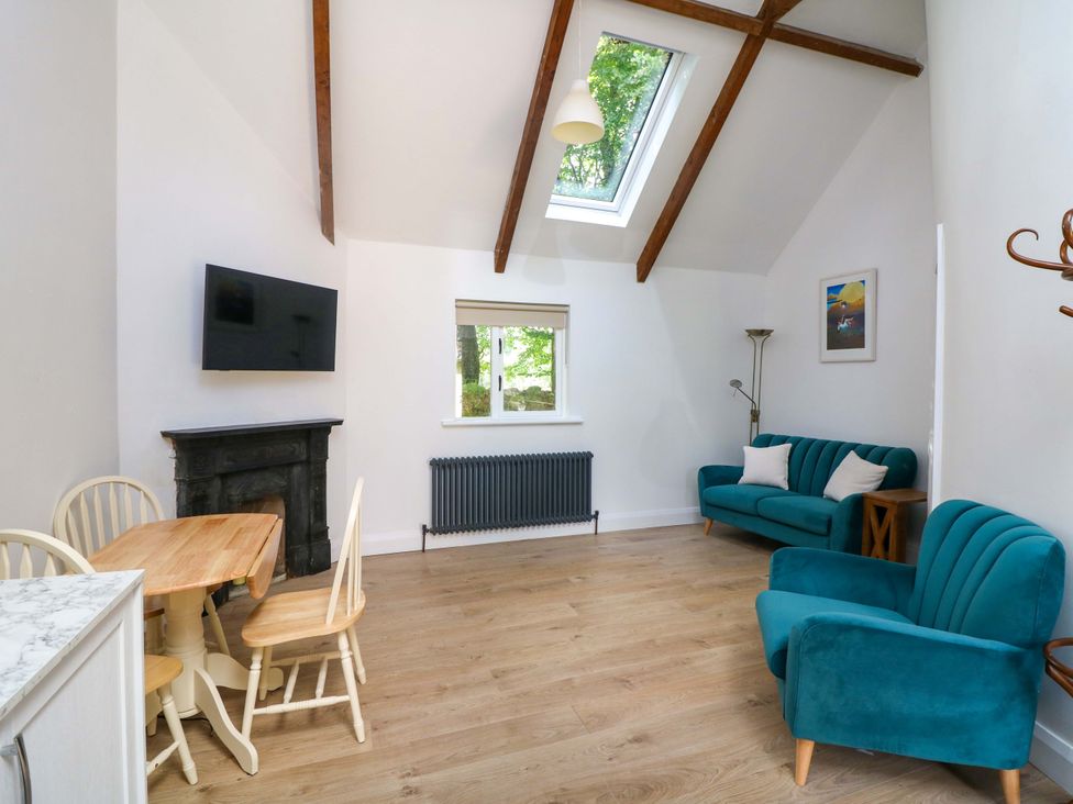 A living room with a sofa and dining table at The Mews @ Derrybawn in Laragh, County Wicklow