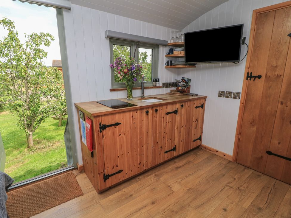 A kitchen with a sink and wooden cabinet at Bramleys in Williton