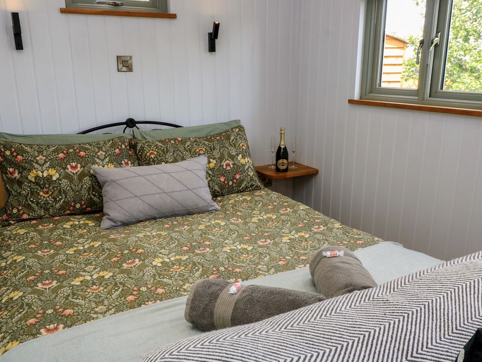 A bedroom with a bed and a bedside table at Bramleys in Williton