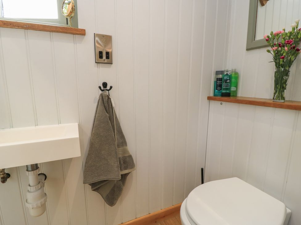 A bathroom featuring a toilet, sink and towel on a rack at Bramleys in Williton