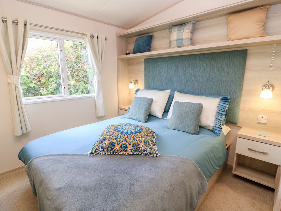 A bedroom with a bed and window at Swanny View in Swanage