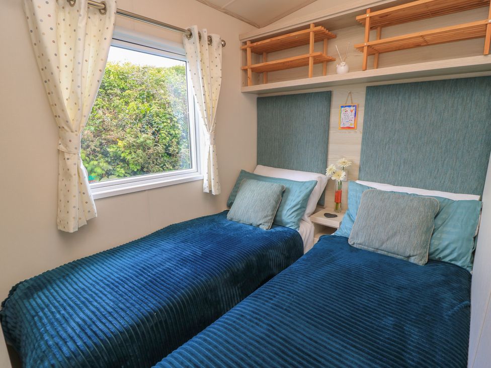 A bedroom with twin beds and a window at Swanny View in Swanage