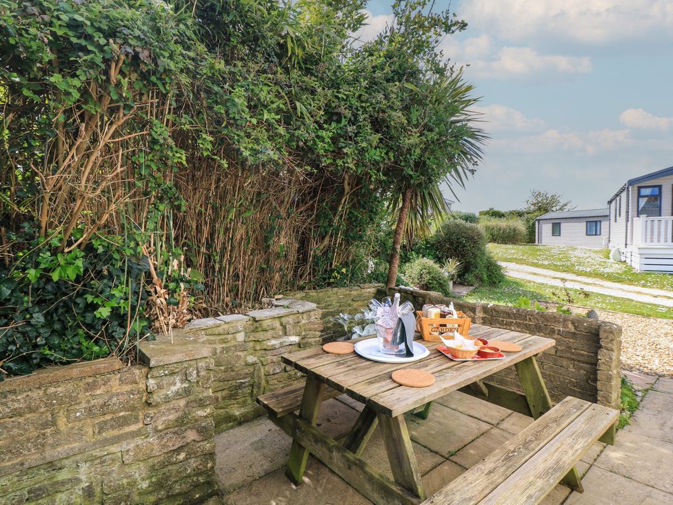 A garden with a picnic table and a plate of food at Swanny View in Swanage