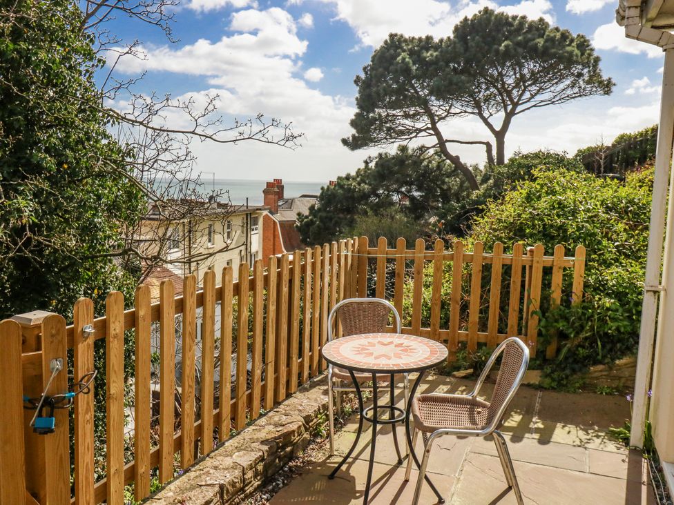 An outdoor seating area with a table and chairs at Flat B in Bournemouth