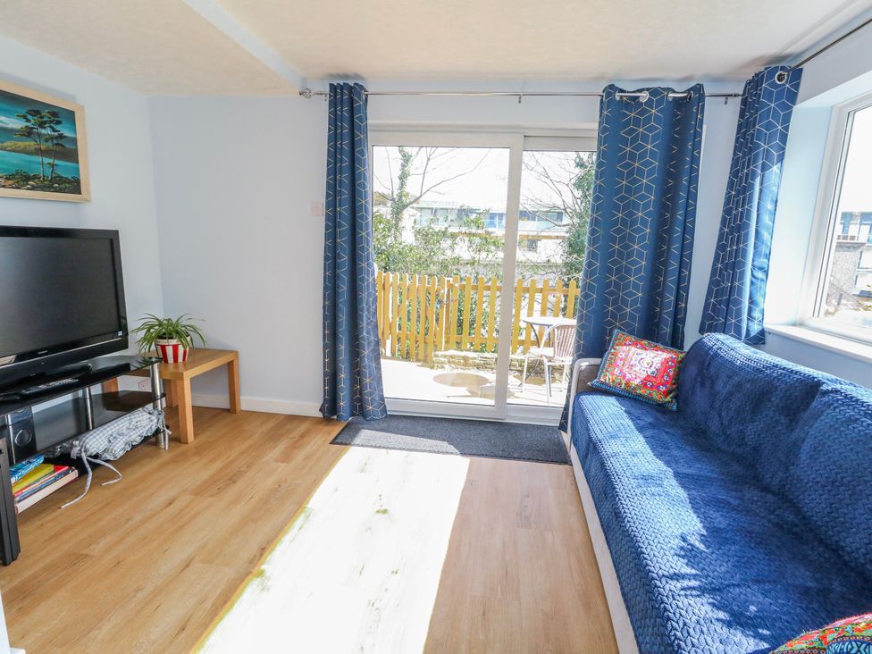 A living room with a television and sliding door at Flat B in Bournemouth