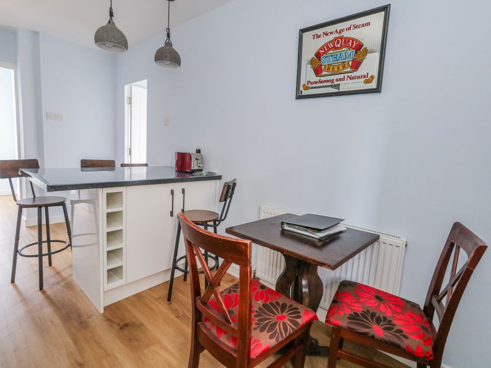 A kitchen with a bar counter and dining area at Flat B in Bournemouth