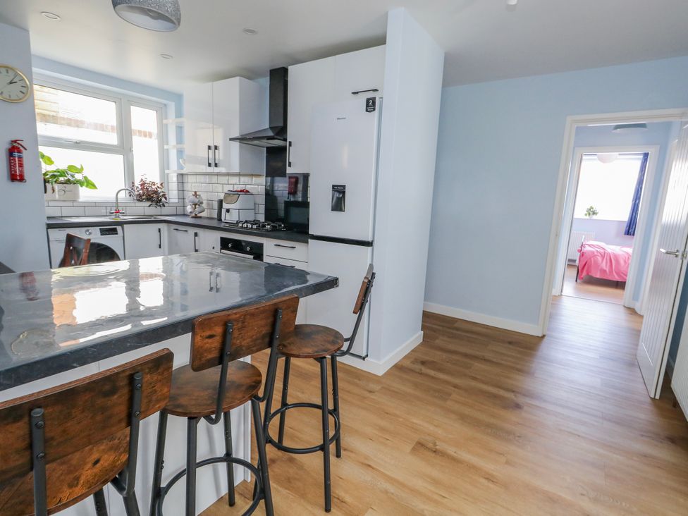 A kitchen with a sink and refrigerator at Flat B in Bournemouth