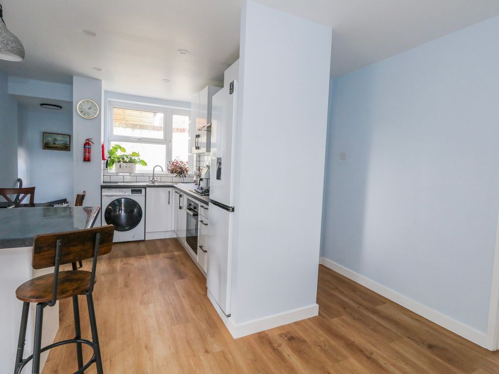 A kitchen with appliances and seating at Flat B in Bournemouth