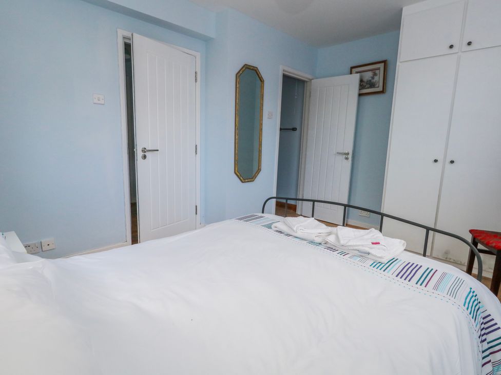 A bedroom with a bed and mirror at Flat B in Bournemouth