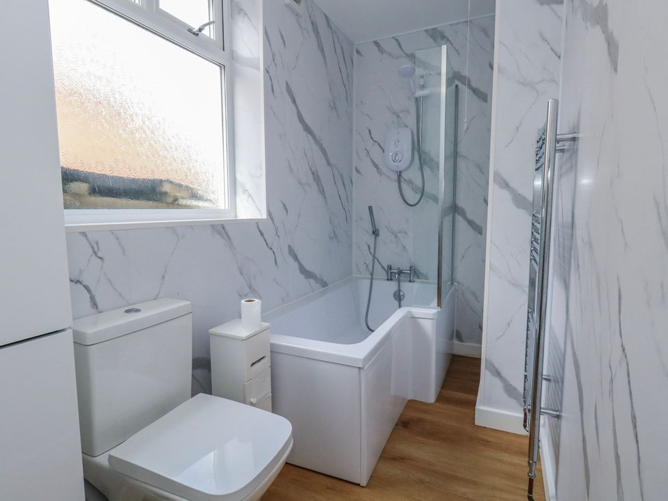 A bathroom with a bath tub and toilet at Flat B in Bournemouth