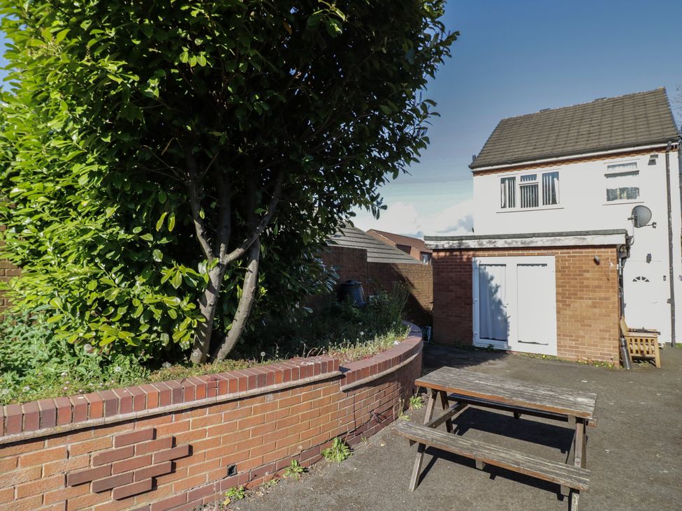 A garden with a tree and a table at 32A Cramp Hill- 1 bed Darlaston