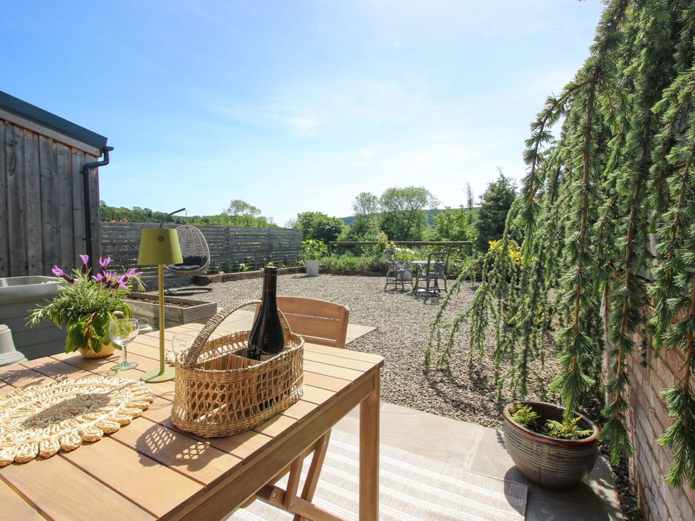 A garden with a table, chairs, and a view at Thyme Away in Bucknell