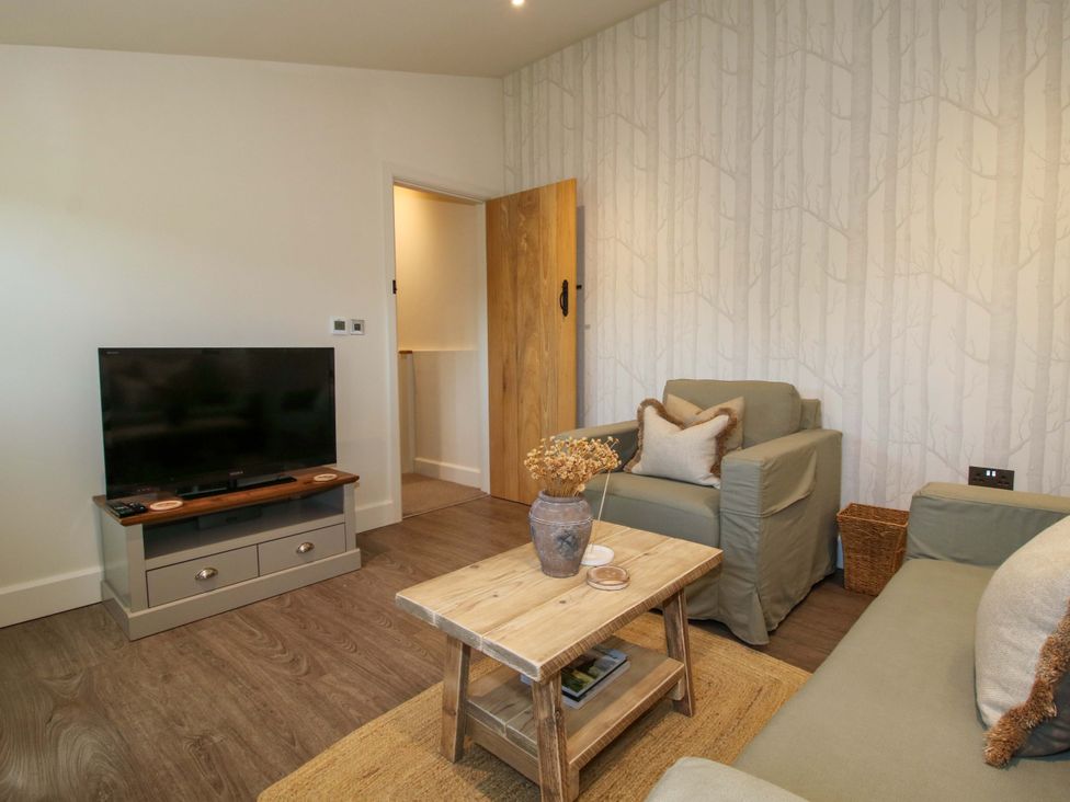 A living room with a television, sofa, and coffee table at Thyme Away in Bucknell