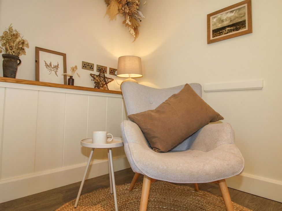 A snug with an armchair and side table at Thyme Away in Bucknell