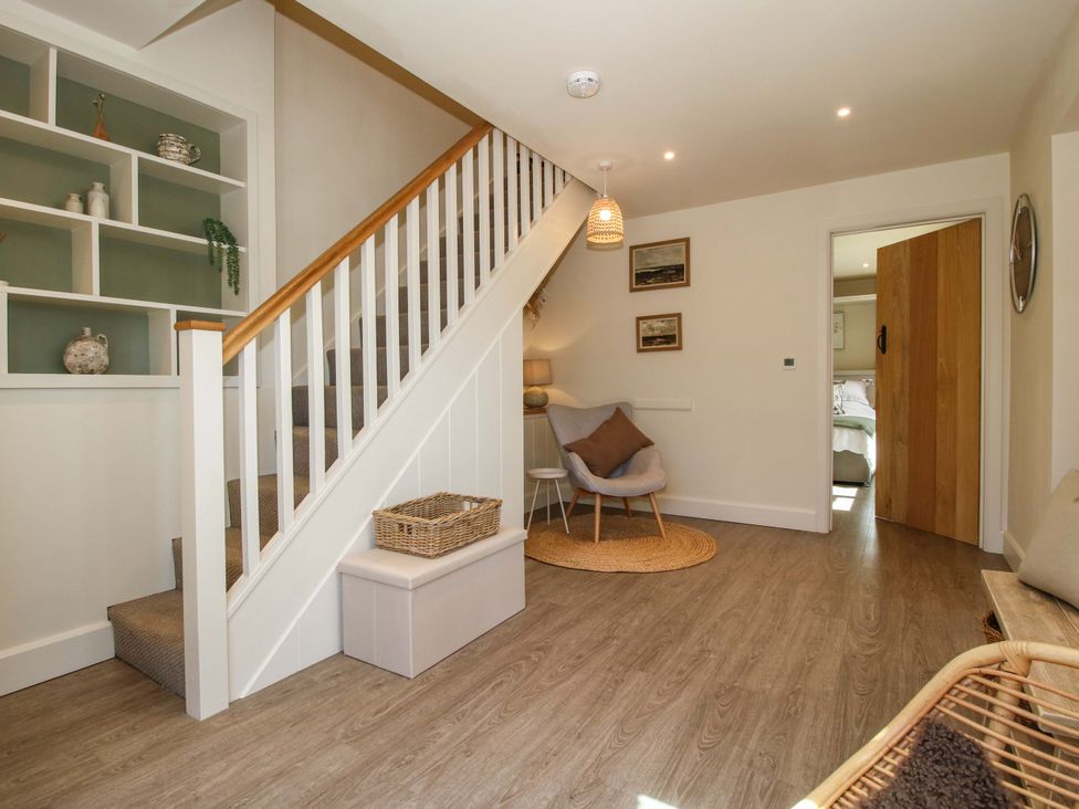 A hallway with a staircase and a chair at Thyme Away in Bucknell