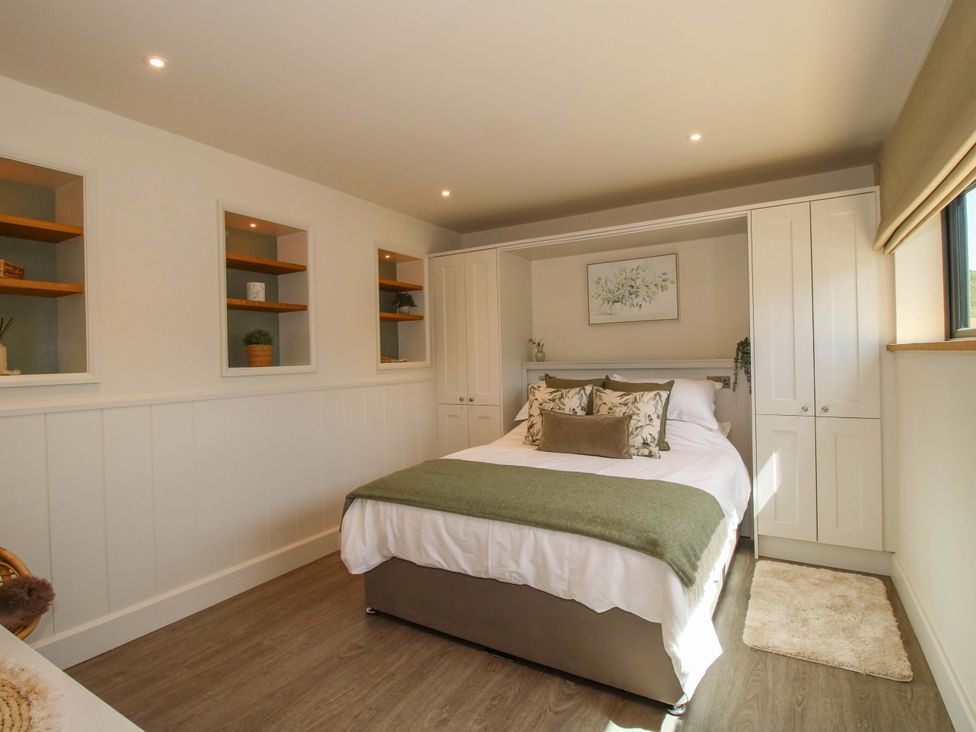 A bedroom with a bed and shelves at Thyme Away in Bucknell