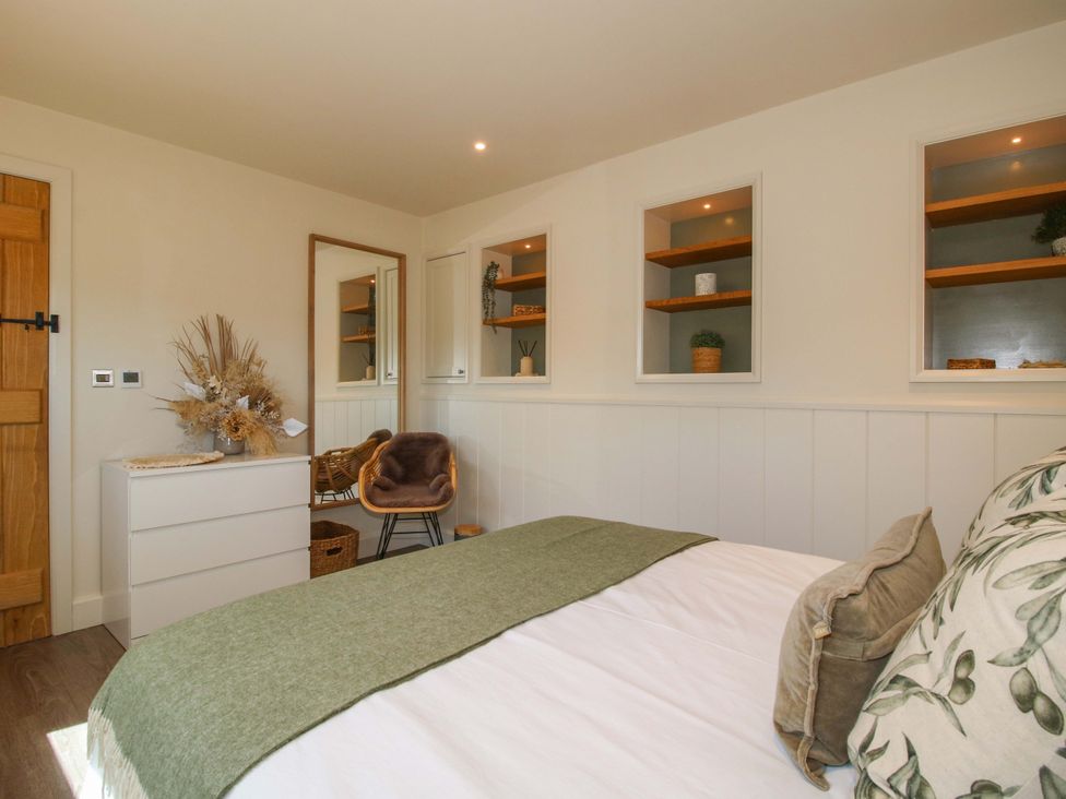 A bedroom with a bed and shelves at Thyme Away Bucknell