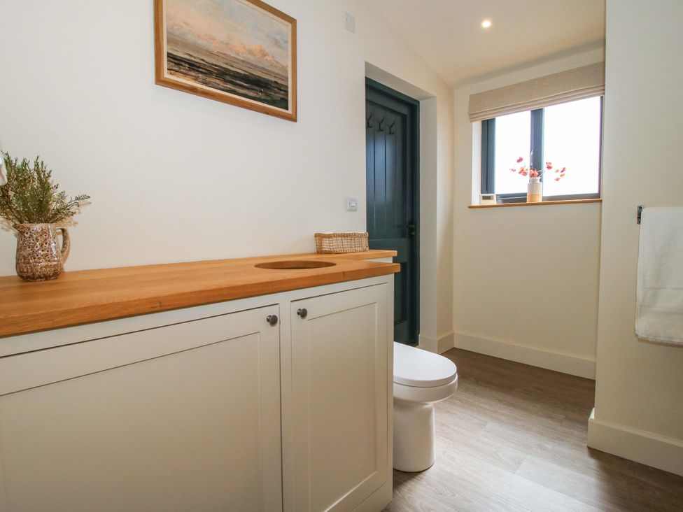 A bathroom with a toilet and wooden countertop at Thyme Away in Bucknell
