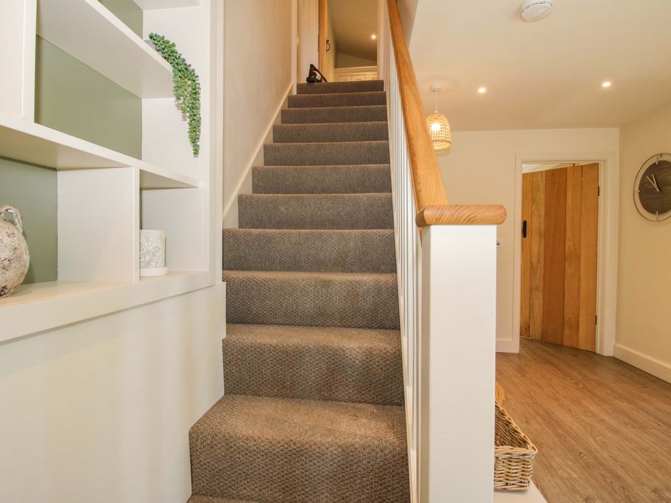 A hallway with stairs and shelves at Thyme Away in Bucknell