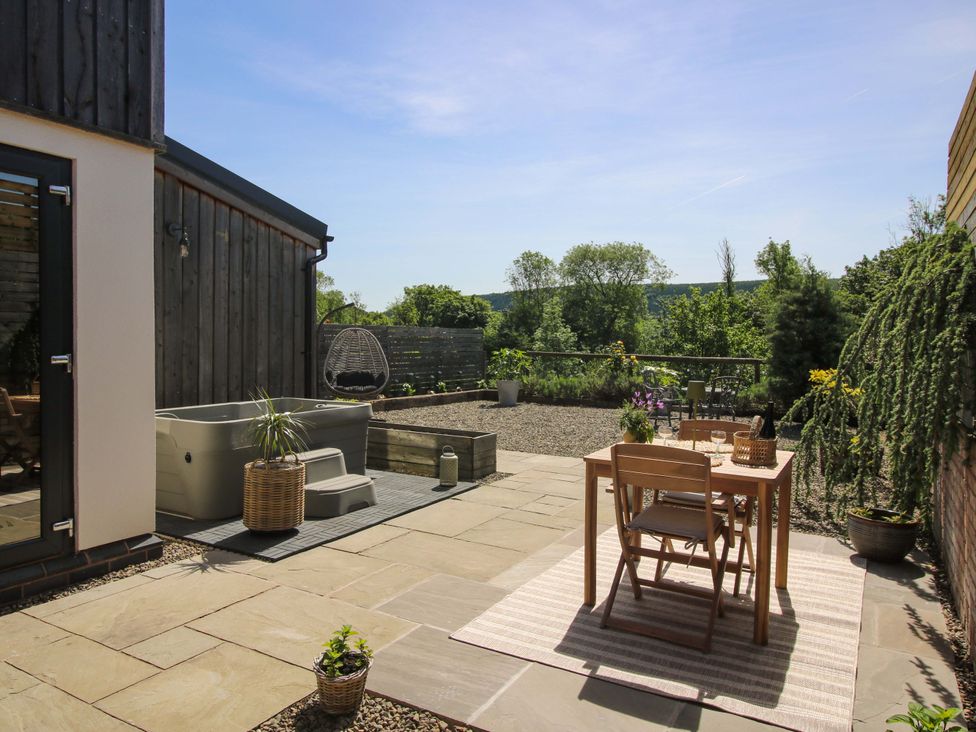 An outdoor area with a hot tub and seating at Thyme Away in Bucknell