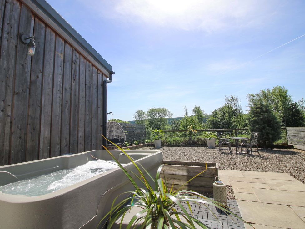 An outdoor area with a hot tub and a table with chairs at Thyme Away in Bucknell