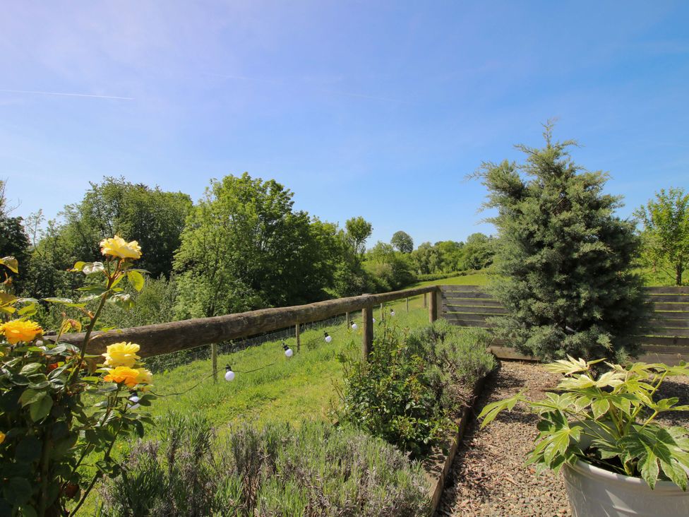 A garden with flowers and a fence at Thyme Away in Bucknell