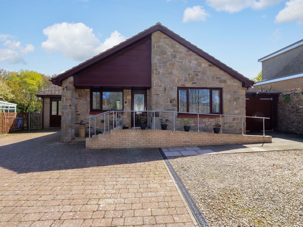 A house with a driveway and steps at Willow cottage in Seahouses